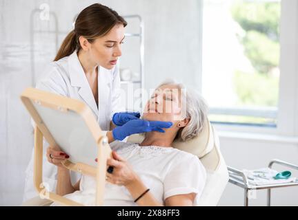 Der ältere Patient sieht in der Klinik in den Spiegel. Stockfoto