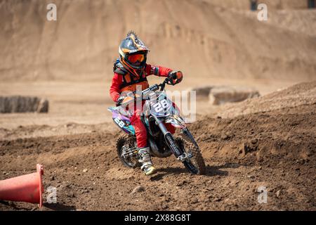 Dreckiges Motobike mit Kind auf dem Sitzplatz im Kreuz. Schön Stockfoto