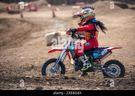 Dreckiges Motobike mit Kind auf dem Sitzplatz im Kreuz. Schön Stockfoto