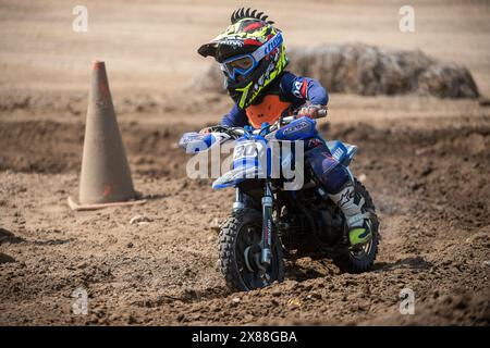 Dreckiges Motobike mit Kind auf dem Sitzplatz im Kreuz. Schön Stockfoto