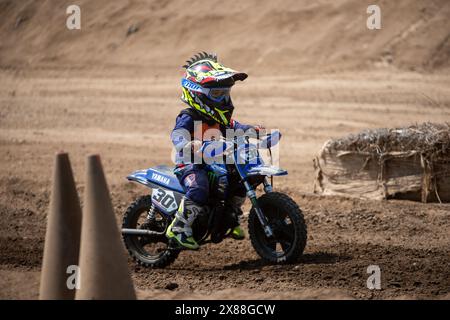 Dreckiges Motobike mit Kind auf dem Sitzplatz im Kreuz. Schön Stockfoto