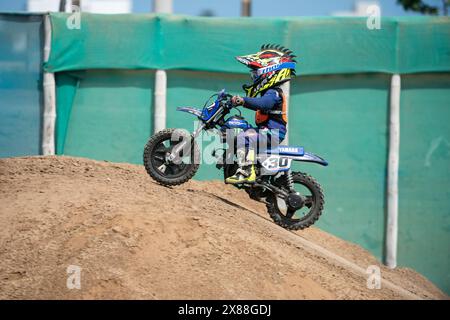 Dreckiges Motobike mit Kind auf dem Sitzplatz im Kreuz. Schön Stockfoto