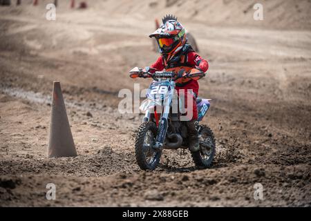 Dreckiges Motobike mit Kind auf dem Sitzplatz im Kreuz. Schön Stockfoto