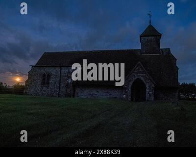 Harty, Kent, Großbritannien. Mai 2024. Wetter in Großbritannien: Der Flower Moon, der neben der Harty Church auf der Isle of Sheppey in Kent aufsteigt. Quelle: James Bell/Alamy Live News Stockfoto