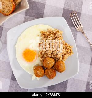 Fleischbällchen mit sonniger Seite nach oben Ei und Haferflocken auf weißem Teller Stockfoto