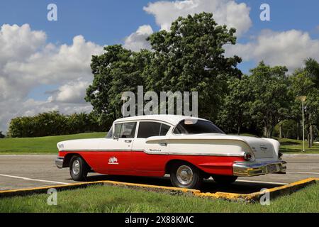 311 seitliche Rückansicht, alter weiß-roter amerikanischer Oldtimer - Chevrolet von 1958 - auf dem Plaza Ernesto Che Guevara Platz. Santa Clara-Kuba. Stockfoto