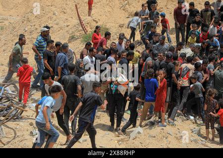 Gaza. Mai 2024. Menschen kämpfen um humanitäre Hilfe, die am 23. Mai 2024 in Khan Younis im südlichen Gazastreifen von einem Flugzeug abgelassen wurde. Die Mehrheit der Bevölkerung im Gazastreifen leidet seit Ausbruch des Krieges unter einem Mangel an Nahrungsmitteln, Medikamenten und humanitären Grundbedürfnissen. UN-Organisationen warnten vor schlimmen Folgen in der Enklave, darunter Hungersnöte und die Ausbreitung von Epidemien und Krankheiten unter der lokalen Bevölkerung. Quelle: Rizek Abdeljawad/Xinhua/Alamy Live News Stockfoto