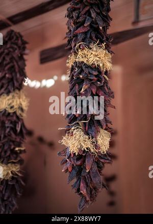 Die roten Chili-Ristras, eine kulturelle Ikone von New Mexico, hängen an der Vorderseite eines Ortes in Mesilla, NM, USA Stockfoto