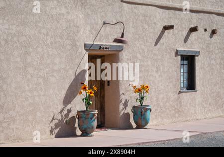 Eintritt in Eine Wohnung im New Mexican Stil mit türkisfarbenen Pflanztöpfen mit schwerer Patina, die Pop-Art-Blumen aus Metall in Las Cruces, NM, USA Stockfoto