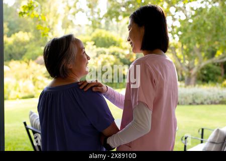 Draußen, asiatische junge Krankenschwester, Patienten mittleren Alters lächeln Stockfoto