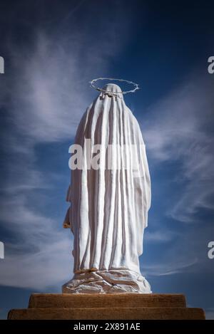 Rückansicht der Jungfrau Maria mit Halostatue vor einem interessanten Himmel in einer spirituellen und konzeptuellen Präsenz Stockfoto