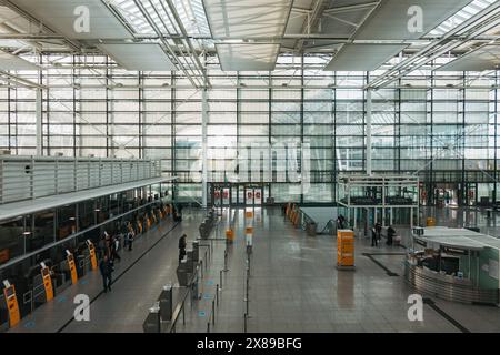 Ein leerer Check-in-Bereich im Terminal 2 am internationalen Flughafen München an einem ruhigen Nachmittag. An den Fenstern lässt sich viel natürliches Licht hereinlassen Stockfoto