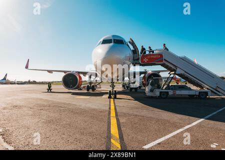 Eine erste Aufnahme eines Airbus A320 Passagiere steigen an einem sonnigen Nachmittag über eine Treppe auf dem Asphalt am Malta International Airport ein Stockfoto