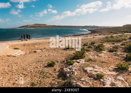 Taucher rüsten sich an den zerklüfteten Ufern des Qawra Point Beach, St. Paul's Bay, Malta Stockfoto