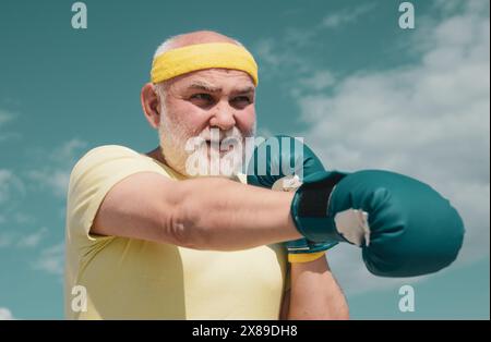 Bestes Cardio-Workout. Älterer Mann, der auf einen Boxsack trifft. Gesunde Kämpfer Senior alten Mann Boxhandschuhe. Boxer mit Boxhandschuh. Ich liebe Boxen. Schön Stockfoto