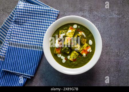 „Palak Paneer“ indisches Essen aus Spinat und Hüttenkäse mit einer weißen Keramikplatte. Stockfoto