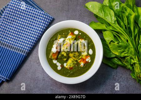 „Palak Paneer“ indisches Essen aus Spinat und Hüttenkäse mit einer weißen Keramikplatte. Stockfoto