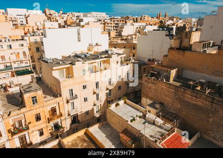 Wohnwohnungen mit sandiger Farbpalette an der Küste verstreuen die Skyline der Stadt Sliema, Malta Stockfoto