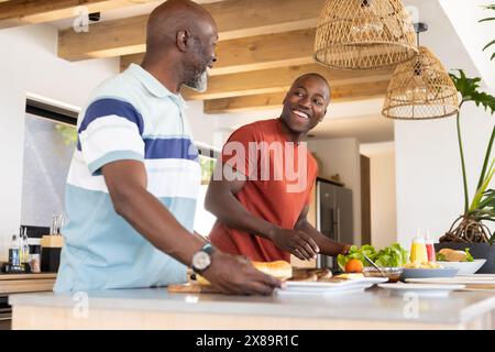 Ein afroamerikanischer Seniorenvater und erwachsener Sohn, der zu Hause kocht Stockfoto