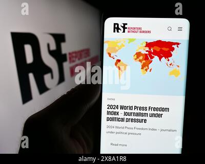 Person, die ein Mobiltelefon hält, mit der Webseite der internationalen Organisation Reporter ohne Grenzen vor dem Logo. Konzentrieren Sie sich auf die Mitte des Telefondisplays. Stockfoto