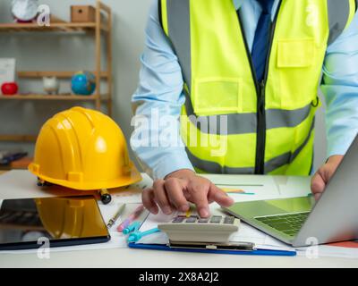 Architekt oder Ingenieur, der Computer verwendet, um am Schreibtisch zu arbeiten, Kostenberechnung, Bauplanung, Strukturberechnung, Baukostenplanung, Fil Stockfoto