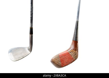 Zwei Vintage-Golfschläger aus Holz mit Gebrauchsspuren, einer mit rotem Griff, isoliert auf weißem Hintergrund, symbolisiert klassische Golfausrüstung und Sport h Stockfoto