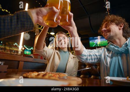 Freunde trinken Bier und feiern das Ende der Arbeitswoche in einem Pub Stockfoto