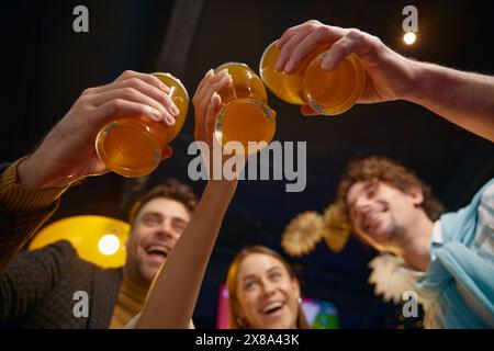 Freunde, die eine Brille anschlagen, feiern den Sieg der Fußballmannschaft im Match Stockfoto
