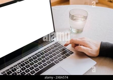 Nahaufnahme eines Mannes, der auf die Eingabetaste eines Laptops auf dem Tisch drückt. Leerzeichen für Text. Telearbeit. Freiberuflich. Stockfoto