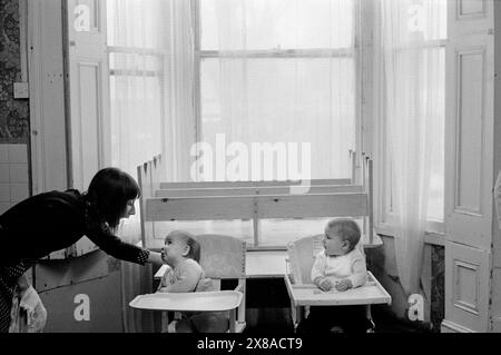 Chiswick Women's Aid, Richmond, London, England um November 1975. Eine Mutter und zwei junge Babys. 1970S UK HOMER SYKES Stockfoto