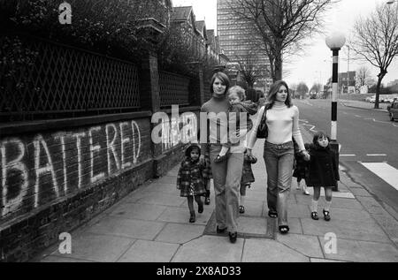 Chiswick Women's Aid 1970s UK. Zwei junge Mütter aus dem Refuge bringen ein paar Kinder, die im sicheren Haus wohnen, zu einem Spaziergang zu den örtlichen Geschäften. London, England November 1975. HOMER SYKES Stockfoto