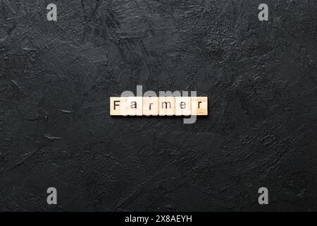 BAUERNWORT auf Holzblock geschrieben. FARMER Text auf Zementtisch für Ihr Design, Konzept. Stockfoto