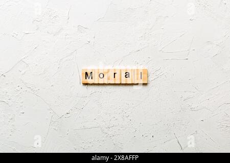 Moralisches Wort auf Holzblock geschrieben. Moralischer Text auf dem Tisch, Konzept. Stockfoto