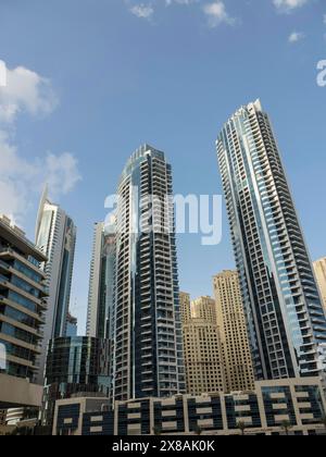 Mehrere Wolkenkratzer stehen hoch vor dem klaren Himmel in Dubai, moderne Skyline mit imposanten Wolkenkratzern und Glasfassaden, Dubai, Vereinigte Arabische Emirate Stockfoto