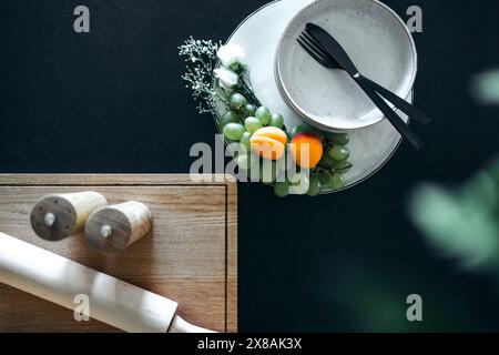 Eleganter Tisch mit Obst, Besteck und Holzschneidebrett Stockfoto