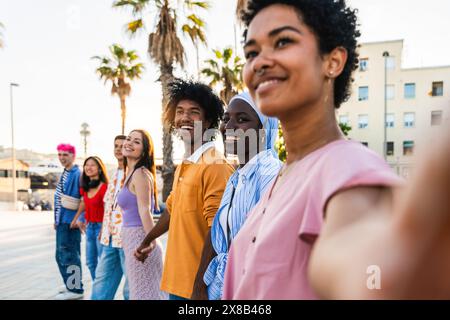 Multiethnische Gruppe junger glücklicher Freunde, die in der Stadt herumhängen - multiethnische Gruppe von Studenten, die sich treffen und Spaß im Freien haben, Konzepte über die Jugend Stockfoto