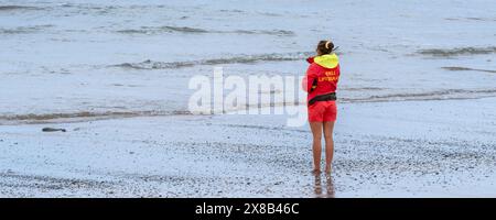 Ein Panoramabild einer RNLI-Rettungsschwimmerin im Dienst am Fistral Beach in Newquay in Cornwall in Großbritannien. Stockfoto