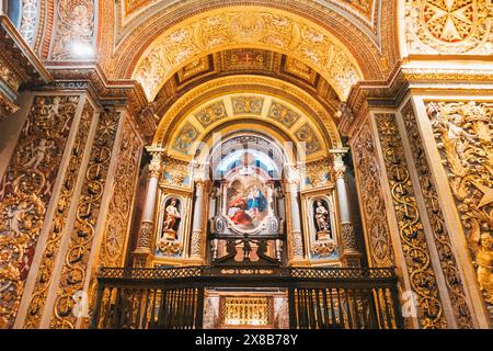 Ein Blick auf das komplizierte Innere der St. John's Co-Cathedral, Malta mit einer goldenen Decke, verzierten Säulen und religiösen Gemälden. Stockfoto