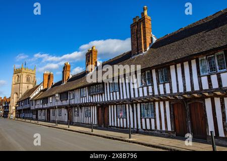 Wunderschöne Almshouses aus dem 15. Jahrhundert in der historischen Stadt Stratford-upon-Avon, Großbritannien. Der Turm der Gildenkapelle ist in der Ferne zu sehen. Stockfoto