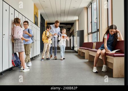Eine Gruppe von Einzelpersonen, einschließlich eines Lehrers, die in einem Flur neben Schließfächern stehen und sich an Gesprächen und Unterweisungen beteiligen. Stockfoto