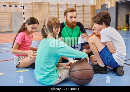 Eine vielfältige Gruppe junger Menschen genießt einen Moment der Zweisamkeit auf einem Basketballfeld, in Gesprächen Stockfoto