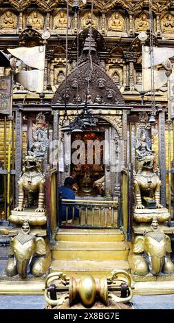 NEPAL, KATHMANDU, PATAN, Dezember 2023, Priester und Devotee am Haupttempel von Hiranya Varna Mahavihar, Goldener Tempel Stockfoto