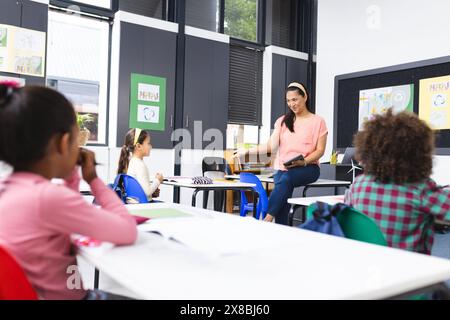 In der Schule unterrichtete eine junge, birassische Lehrerin eine Klasse Stockfoto