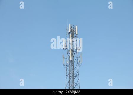 Der Telekommunikationsturm steht hoch vor einem hellblauen Himmel Stockfoto