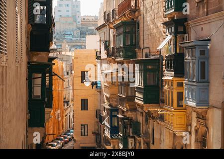 Die Nachmittagssonne trifft auf die Galariji (maltesische Erkerfenster), die aus der Seite der Wohnungen in einer Stadtstraße in Valletta, Malta, ragen Stockfoto