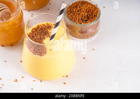 Bienenpollenschale, cremiger warmer oder kalter Shake-Smoothie goldfarbenes Getränk Stockfoto