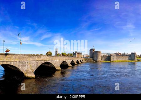 Die Thormond Bridge aus dem 19. Jahrhundert über den Fluss Shannon in Limerick City, Irland, wird von King John's Castle aus dem 13. Jahrhundert bewacht. Stockfoto