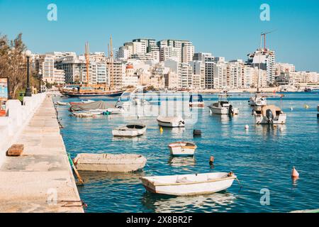 Kleine Boote ankern im Hafen von Sliema an einem ruhigen, sonnigen Tag in Malta Stockfoto