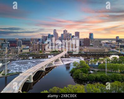 Die Skyline der Innenstadt von Minneapolis, Minnesota, USA über dem Fluss in der Abenddämmerung. Stockfoto