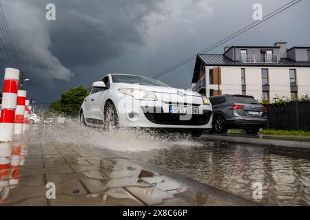 Krakau, Polen, 24. Mai 2024. Ein Auto fährt durch eine tiefe Pfütze auf einer Straße in einem Wohngebiet, während ein Sturm mit starkem Wind und Hagel durch Krakau zieht. Quelle: Dominika Zarzycka/Alamy Live News. Stockfoto